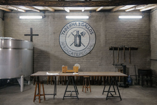 taberna 3 gallos Brewery interior with a large logo on the wall and wooden tables.