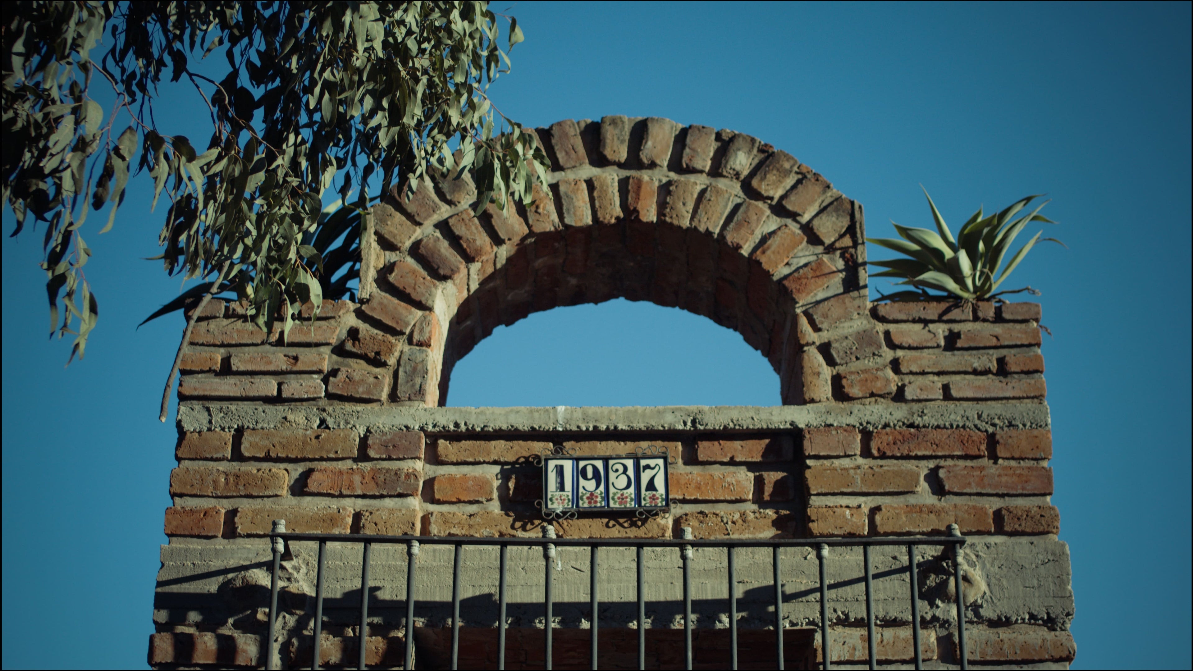 el viejito Brick archway with '1937' inscription against a clear blue sky